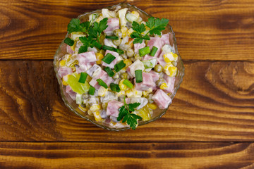 Fototapeta na wymiar Tasty salad with sausage, green pea, canned corn, bell pepper, cucumber and mayonnaise on wooden table. Top view