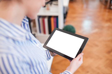 Over the shoulder view of a young businesswoman holding a digital tablet with blank black screen, copyspace.