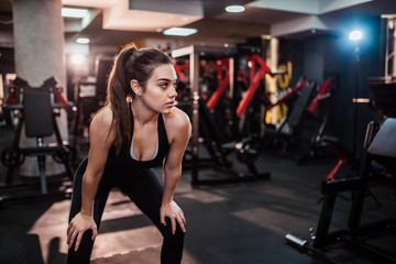 Obraz na płótnie Canvas Girl taking a break between exercises in the gym.