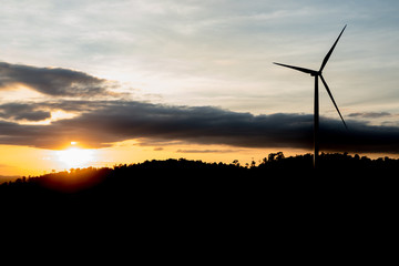 Silhouette of wind turbines on the mountain at sunset.