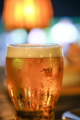 A glass of beer with colorful light background