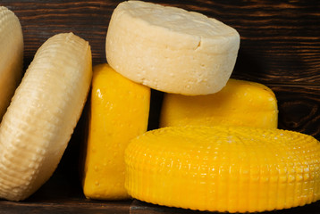 Different cheese on wooden background.