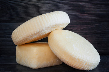 Homemade cheese on dark wooden background.