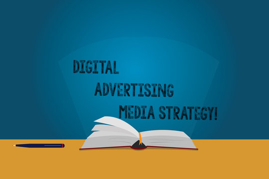 Handwriting text Digital Advertising Media Strategy. Concept meaning Search engine optimization promotion Color Pages of Open Book photo on Table with Pen and Light Beam Glaring - Powered by Adobe
