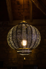 Beautiful moroccan style lamp made of pierced silver metal; country house interiors.