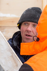 Two workers in overalls at a construction site