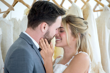 young couple in love Wedding Bride and groom kissing in dress store or shop . . Newlyweds. Closeup portrait of a beautiful having a romantic moment together