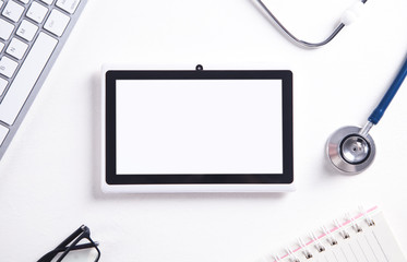 Tablet, stethoscope, keyboard, glasses and notepad. Medical concept