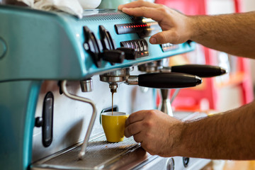 men's hands doing espresso in a cafe