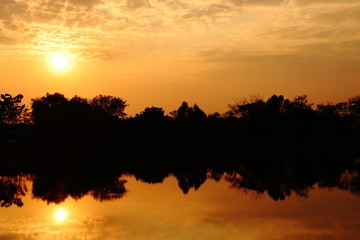 Landscape with sunset over the lake with the reflection of light on the surface of the water