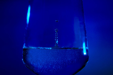 Rotweinglas mit eingefrorenen herabfallenden Wassertropfen 