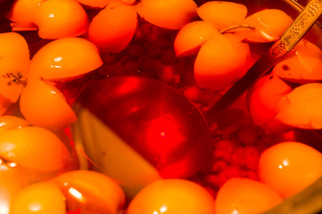 Fruit compote of apples in a saucepan with a ladle, close up