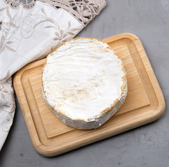 round piece of brie cheese on a wooden board