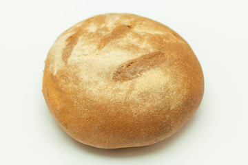 whole loaf of round freshly baked bread close up on white background