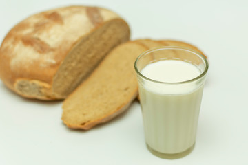 sliced pieces of bread and a glass of milk next to on a white background