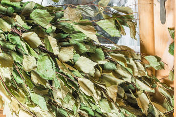 Green birch broom lies on a window in a bath