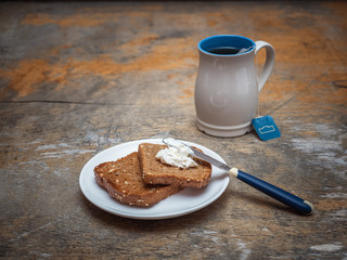 A high bright mug with packaged tea, toasts on a saucer.
