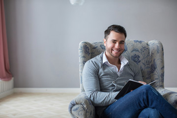 Male psychiatrist with pencil and clipboard looking at camera.