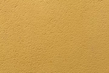 Fotobehang Yellow ochre painted stucco wall. Background texture. © Vladimir Wrangel