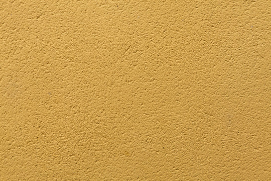 Yellow ochre painted stucco wall. Background texture.