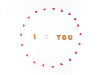 Valentine's day concept. Declaration of love, frame made of paper hearts. In the center engagement ring. Flat lay, top view, white background, isolated, copy space