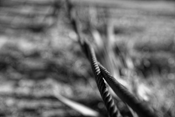 Thick steel rope close up. Bridge fence element. Detailed view. The surface of the steel cable is covered with rust.