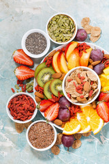plate of fresh seasonal fruits and superfoods on rustic background, vertical, top view