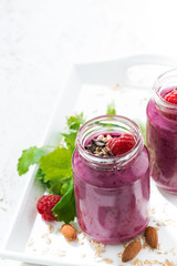 raspberry smoothie with oatmeal and chocolate on white table, vertical, top view