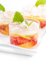 refreshing lemonade with strawberry and lemon on a tray, vertical, closeup