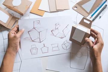 Designer sketching drawing design Brown craft cardboard paper product eco packaging mockup box...