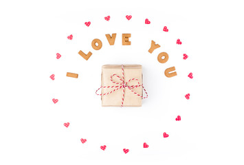 Valentine's day concept. Declaration of love, frame made of paper hearts. In the center gift in craft paper. Flat lay, top view, white background, isolated, copy space