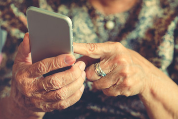 Hands of an elderly woman holding a mobile phone