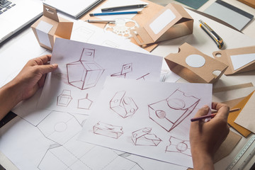 Designer sketching drawing design Brown craft cardboard paper product eco packaging mockup box...