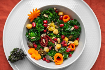Bowl with calettes (cross between Brussels sprouts and green cabbage), pomegranate seeds, carrots, chickpeas and seeds