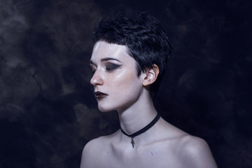 A young girl with androgynous appearance and dark gothic makeup.
