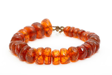 Very beautiful amber beads on a white background. Large orange red amber beads with flat edges. Jewelry women. Sun Stone. Advertising for jewelry shop. Natural mineral. Ancient resin. Sunstone