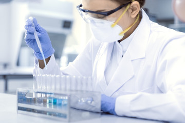 Female scientist in laboratory with test tubes