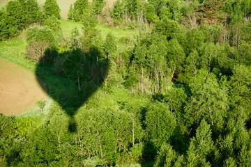 The shadow of the balloon on the background of a green meadow.