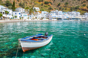 Fishing boat and the scenic village of Loutro in Crete, Greece - obrazy, fototapety, plakaty