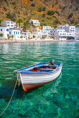 Fishing boat and the scenic village of Loutro in Crete, Greece - obrazy, fototapety, plakaty