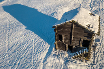 Aerial view of cottage in snow. Remote building with snow covered roof in Switzerland.