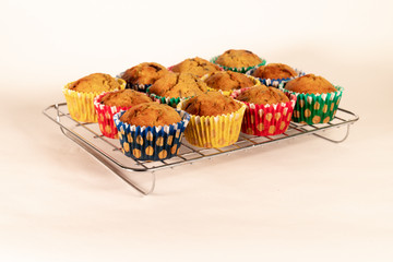 Banana chocolate chip muffins on wire rack, white background, with shallow depth of field.