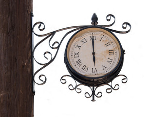 Vintage street clock on a wooden pole isolated on white background