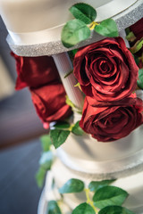 Wedding cake with red rose decoration and cake topper