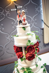 Wedding cake with red rose decoration and cake topper