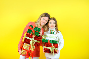Gifts for the holiday, mother with her little daughter holding gifts and smiling, mother's day