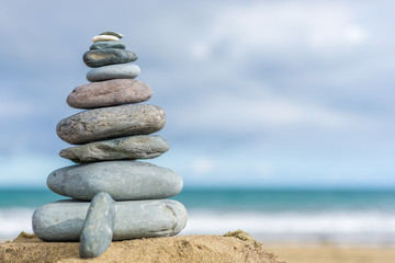 Fototapeta na wymiar Steinturm an einem Strand als Hintergrund mit Textfreiraum