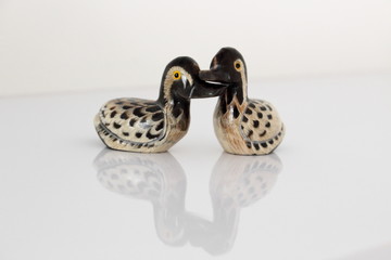 Valentine's day concept. Couple in love, just married or honeymoon concept. Couple of stone mandarin ducks toy with reflection.