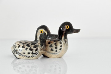 Valentine's day concept. Couple in love, just married or honeymoon concept. Couple of stone mandarin ducks toy looking in the same direction, with reflection.