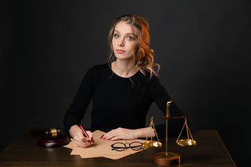 Young lawyer woman in a formal dress sitting at table and writing something by pen, lawyer woman...